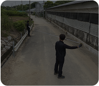 사일로와 돈사 사이 거리를 실측하는 작업자